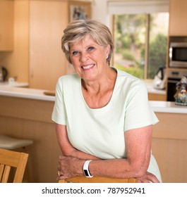 Beautiful Portrait Of Pretty And Sweet Senior Mature Woman In Middle Age Around 70 Years Old Smiling Happy And Friendly At Home Kitchen In Aging And Lifestyle Concept,