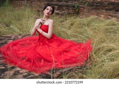 Beautiful Portrait Pretty Woman Red Dressed As An Indian Sexy Girl With Red Lips. Young Hindu Pakistani Bride And Glamour Makeup In A Fashion Jewelry Set. Traditional Indian Red Sari Clothing.