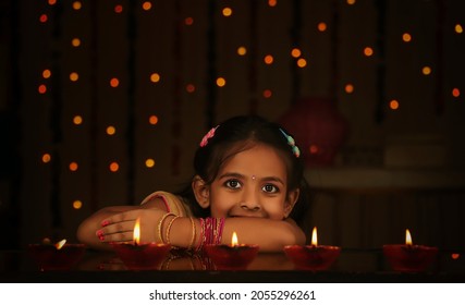 Beautiful Portrait of an smiling girl leaning on table during Diwali festival night