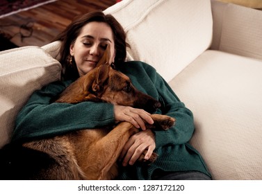 Beautiful portrait of smiling woman hugging her dog german shepherd together in front of fireplace at cozy home in winter day in happiness Friendship Love Companionship and benefits of pets animals. - Powered by Shutterstock