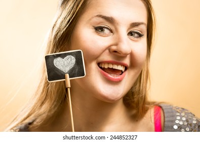 Beautiful Portrait Of Smiling Woman Posing With Decorative Chalk Boar With Drawn Heart