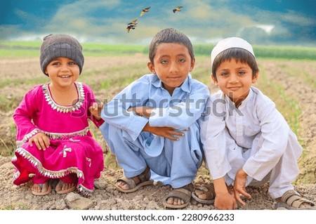 Beautiful portrait of three Pakistani villages kids. Pakistani kids. Asian kids portrait against cloudy sky background. Three Asian kis portrait. Beautiful kids of Punjab Pakistan. Sister brothers.