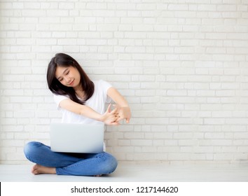 Beautiful portrait young asian woman sitting with laptop stretch and exercise relax after work success on cement concrete background, modern office with copy space, freelance business concept. - Powered by Shutterstock