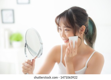 Beautiful portrait young asian woman smile with skin care use oil blotting paper on face look mirror in the room, beauty asia girl happy and cheer makeup and cosmetic, health care on facial concept.