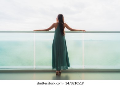 Beautiful portrait young asian woman happy smile relax at balcony with sea ocean view