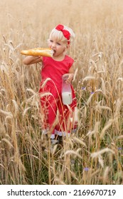 Beautiful Portrait Of A Young Child In A Field. Children With Bread. Little Girl In Cereal Field. Happy Baby Girl On Field Of Wheat With Bread. Food And Drink. Little Girl Drinking Milk.