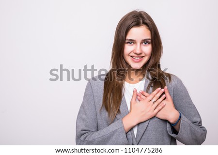 Beautiful positive friendly-looking young mixed race woman with lovely sincere smile feeling thankful and grateful, showing her heart filled with love and gratitude holding hands on her breast
