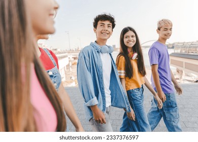 Beautiful, positive smiling multiracial college students walking together on urban street. Stylish authentic teenagers meeting together, talking, communicating. Concept of friendship - Powered by Shutterstock