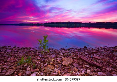 A beautiful pre-dawn sunrise of Longview Lake located just outside of Kansas City with a rocky foreground