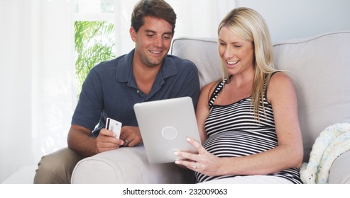 Beautiful pregnant couple shopping for baby supplies at home - Powered by Shutterstock