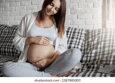 Beautiful pregnant lady caring of her tummy listening for her fetus sitting home. Having a wealthy husband is a key to easy pregnancy. - Powered by Shutterstock