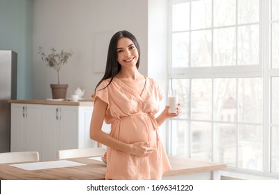 Beautiful Pregnant Woman Drinking Milk In Kitchen