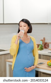 Beautiful Pregnant Woman Drinking Milk In Kitchen