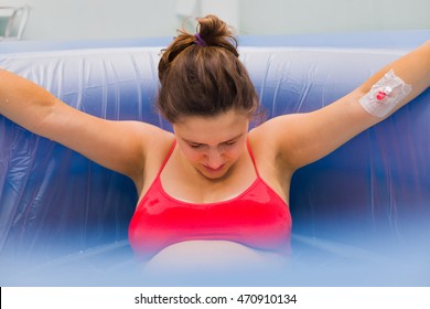 Beautiful Pregnant Woman During Labour In Water Pool Giving Birth.