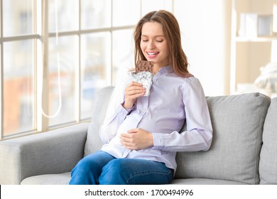 Beautiful Pregnant Woman Eating Chocolate At Home