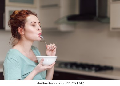 Beautiful Pregnant Woman Eating With Lust Cereals On Breakfast, Enjoying Meal. Yummy Food For Pregnant Ladies