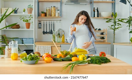 Beautiful Pregnant Woman Happily Preparing a Vegetable Salad, Organic Healthy Food, in a Cozy Home Kitchen. The Concept Of Diet, Proper Nutrition, Healthy Pregnancy and People. - Powered by Shutterstock