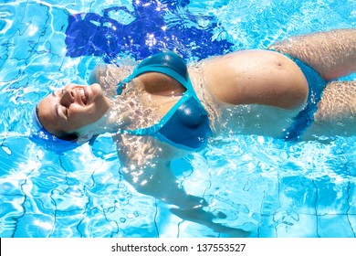 Beautiful pregnant woman happy smiling in swimming pool