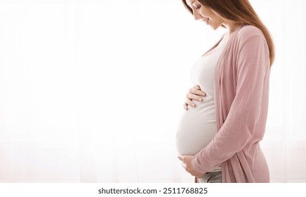 Beautiful pregnant woman hugging her tummy, enjoying her pregnancy, free space - Powered by Shutterstock