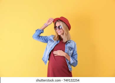 Beautiful pregnant woman on yellow background
