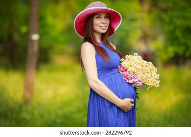 Beautiful Pregnant Woman outdoors with flowers pregnant girl portrait, healthy pregnancy, pregnant young female in park summer, soft focus. series
