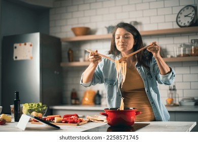 Beautiful pregnant woman preparing delicious food. Smiling woman cooking at home.	