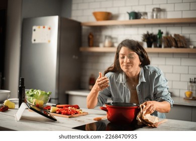 Beautiful pregnant woman preparing delicious food. Smiling woman cooking pasta at home. - Powered by Shutterstock