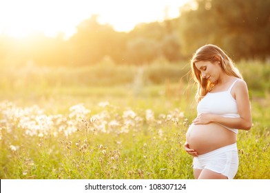 Beautiful Pregnant Woman Relaxing Outside In The Park