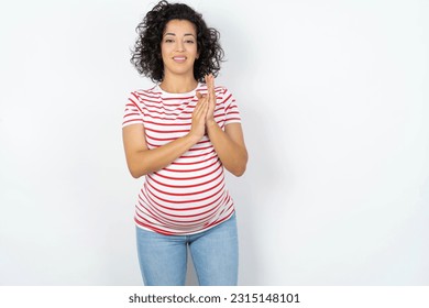 Beautiful pregnant woman standing over white studio background clapping and applauding happy and joyful, smiling proud hands together. - Shutterstock ID 2315148101