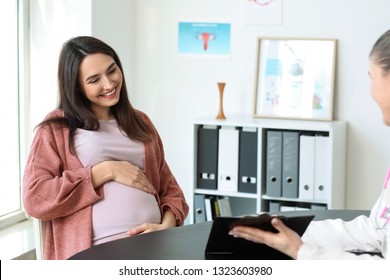 Beautiful pregnant woman visiting her doctor in hospital