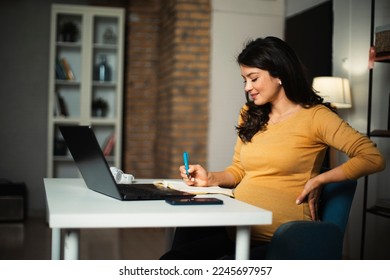 Beautiful pregnant woman working on laptop. Young businesswoman working in her office.	 - Powered by Shutterstock