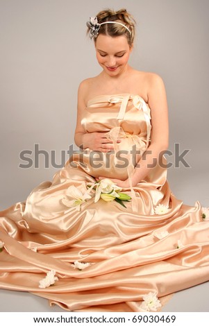 beautiful pregnant woman wrapped in golden silk