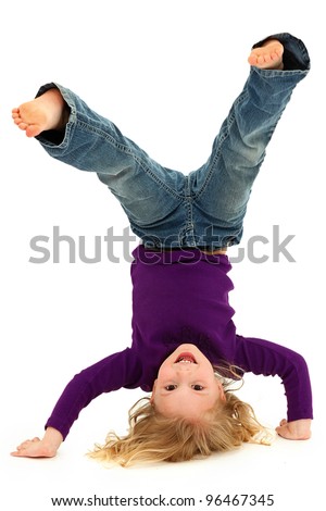 Beautiful Preschool Girl Child Laughing and Doing Hand Stand Over White Background