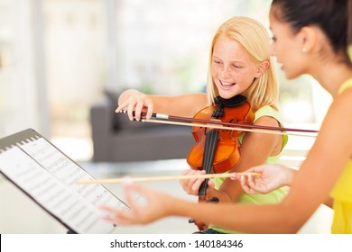 beautiful preteen girl in music class with music teacher - Powered by Shutterstock