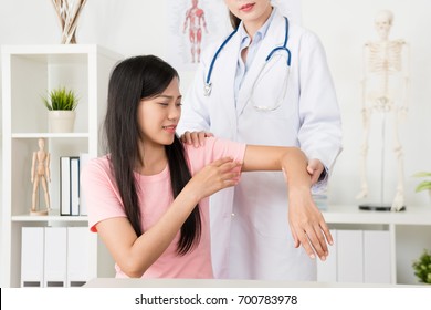 Beautiful Pretty Woman Patient Hurt Arm Feeling Suffering Visiting Hospital Examination And Female Doctor Helping To Adjust Joint.