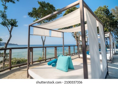 Beautiful private beach cabana daybeds on sand at the resort overlooking the scenic view of Naithon Beach, Phuket, Thailand. A tropical holiday concept.