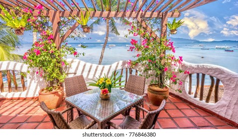 Beautiful Private Resort Balcony With Colorful Flowers In A Vibrant Seaside Setting On A Tropical Island, With Blue Sky And Water In The Background.