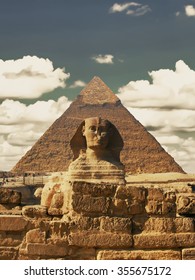 Beautiful profile of the Great Sphinx including pyramids of Menkaure and Khafre in the background on a clear sunny, blue sky day in Giza, Cairo, Egypt. Pyramid Egyptian Sphinx on background of clouds