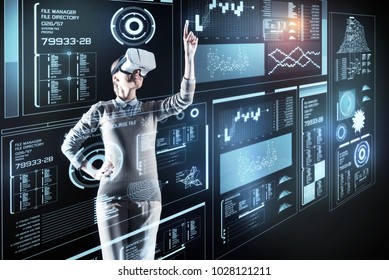 Beautiful programmer. Cheerful optimistic young programmer standing in front of a great futuristic device and feeling happy while wearing modern virtual reality glasses