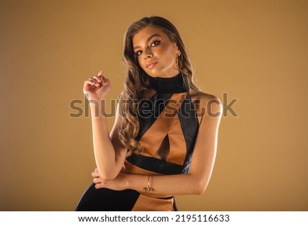 Beautiful prom girl posing with her hand while standing at the studio