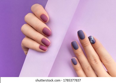 Beautiful purple burgundy matte manicure on creative background. Fashionable spring summer nail design.