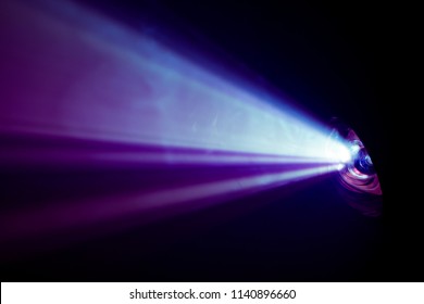 Beautiful Purple Color Wide Lens Projector With Light Beam For Movie And Cinema At Night . Smoke Texture Spotlight . Screening For Multimedia . Black Background .