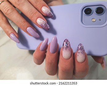 Beautiful purple manicure and shiny gradient design  Woman hands and long round nails   lilac gel polish smartphone background