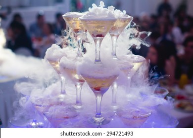 Beautiful pyramid line of different colored alcohol cocktails with mint on a open air party, tequila, martini, vodka, and others on decorated catering bouquet table on open air event 