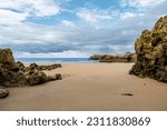 Beautiful and quiet sandy beach with sedimentary rocks outcrops in Playa Virgen del Mar, Costa Quebrada, Cantabria, North Spain