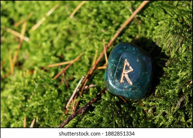 Beautiful Raido Rune made of Bloodstone with mossy background