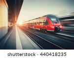 Beautiful railway station with modern high speed red commuter train with motion blur effect at colorful sunset in Nuremberg, Germany. Railroad with vintage toning