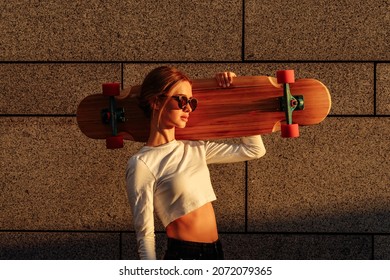 A beautiful ray falls on a woman with a skateboard. High quality photo - Powered by Shutterstock