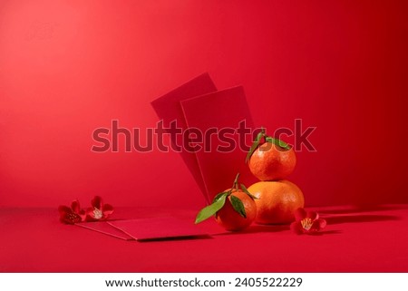 Beautiful red envelopes displayed with several tangerines and small flowers. Chinese people often store lucky money in red envelopes