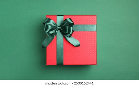 Beautiful red gift box with bright bow on green background, top view. Space for text - Powered by Shutterstock